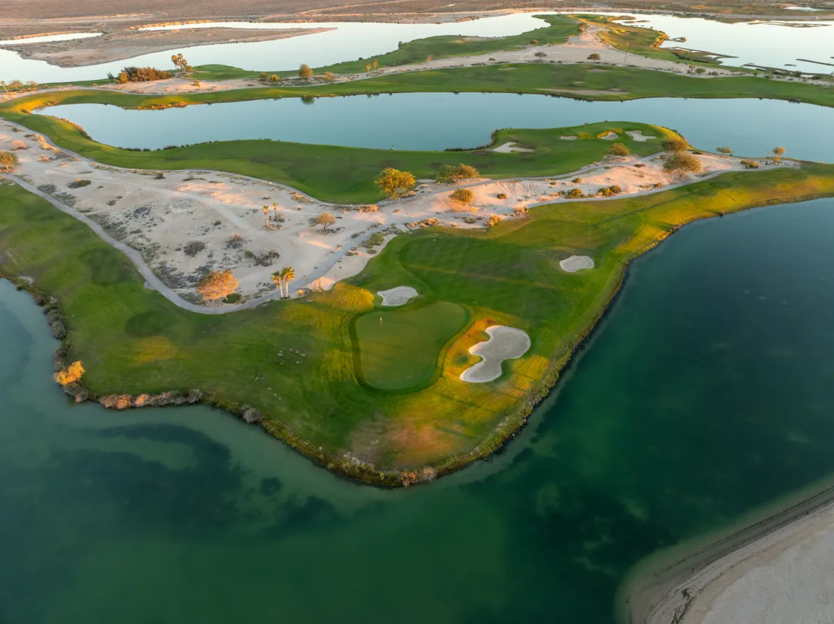 Aerial view of sculpted fairways and greens surrounded by turquoise lagoons