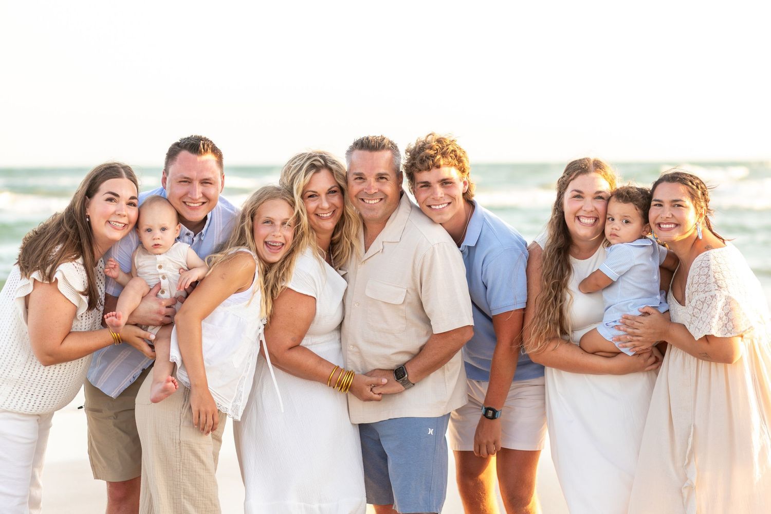Extended family smiling together beside the ocean on a Rocky Point beach